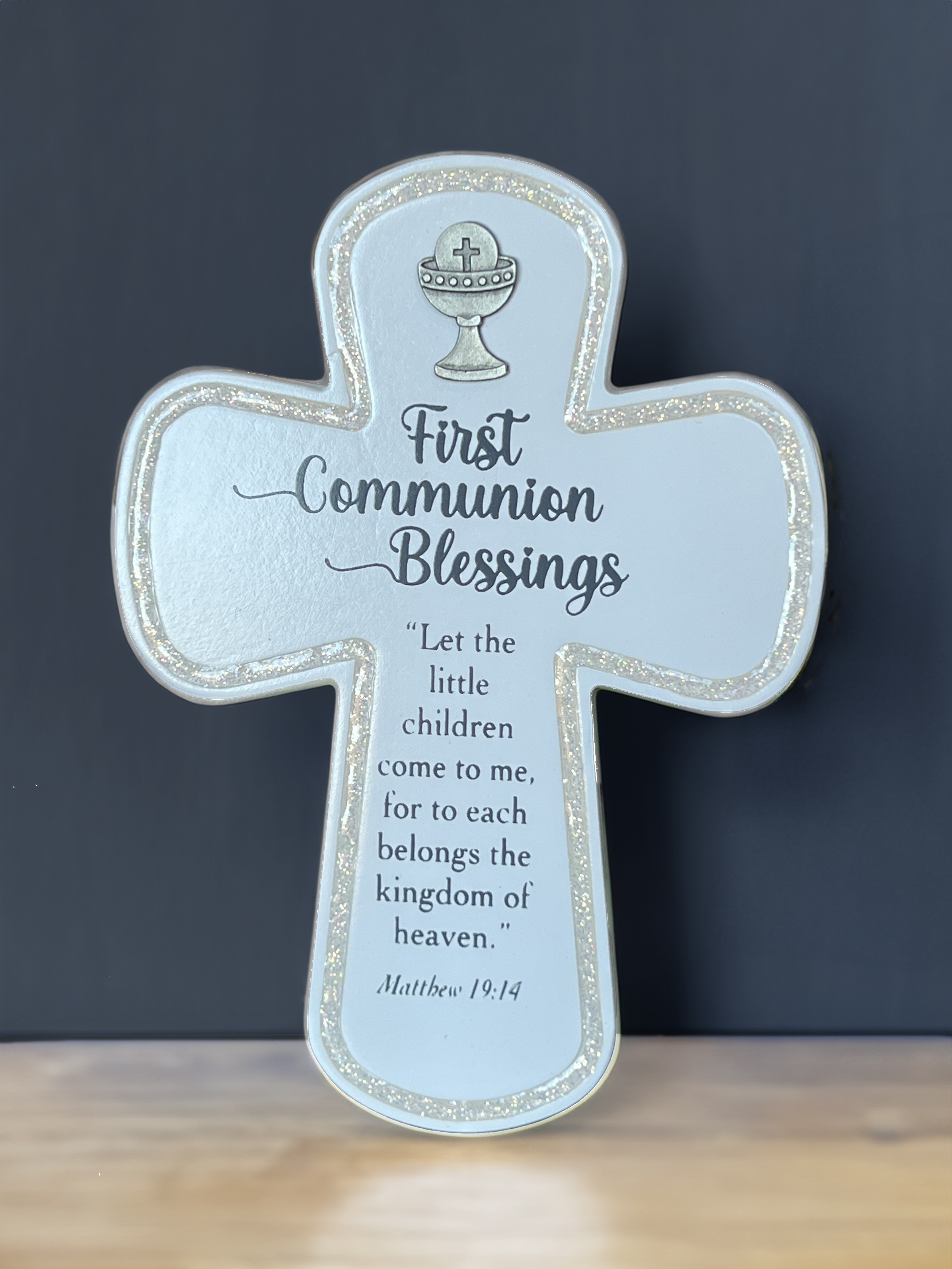 First Communion Standing Cross. Wood with Cast Metal Chalice and Biblical Quote. Features Glitter Epoxy Bevel around the Edge. May Hang or Stand. 4in W x 6in H