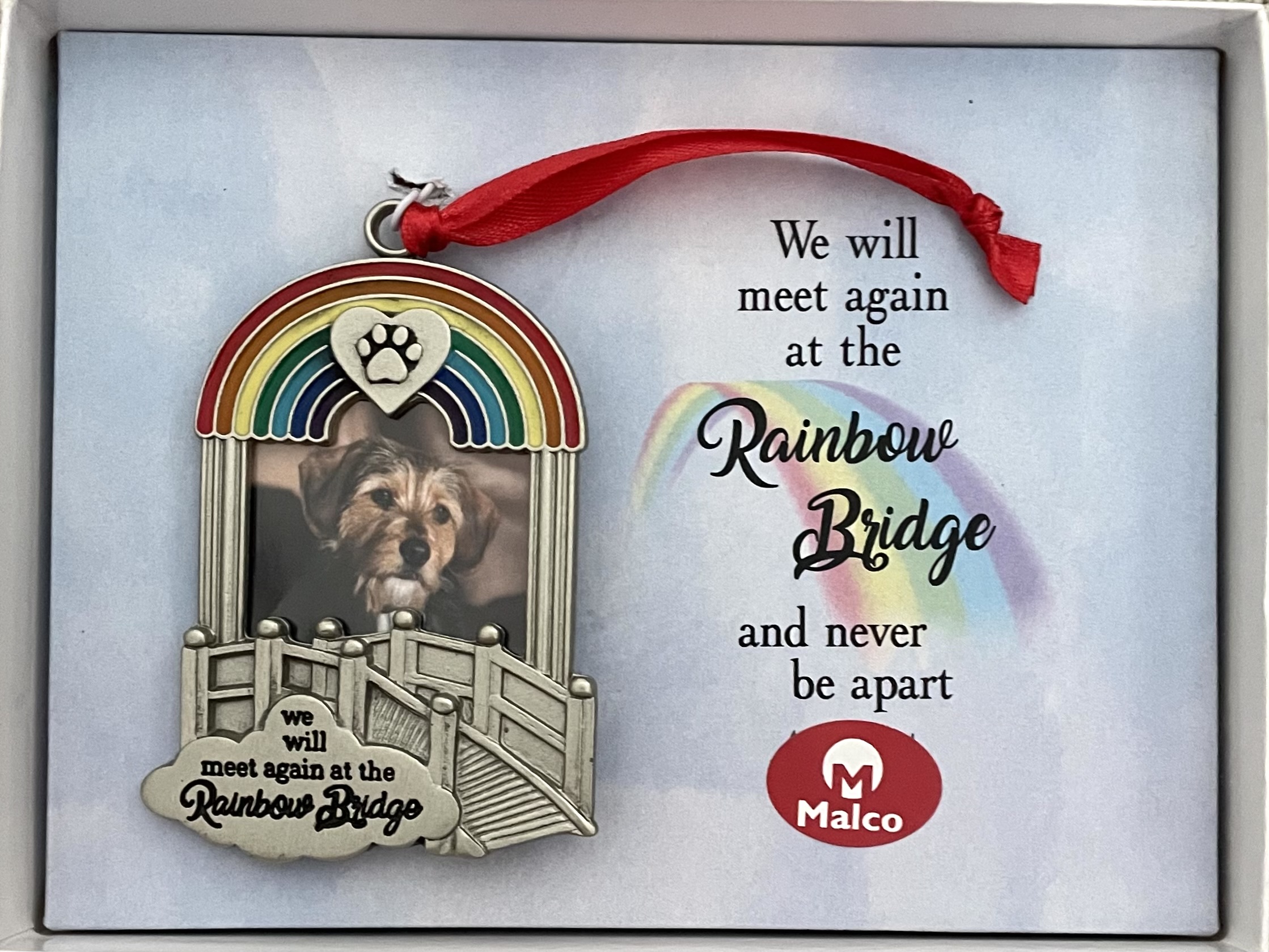 RAINBOW BRIDGE ORNAMENT. METAL WITH SILVER ENAMEL FINISH AND COLORFUL EPOXY FILL. HANGS FROM RED RIBBON. HOLDS 1.5 X 1.25 IN PHOTO. 2.25 X 3.25 IN. WINDOW BOXED