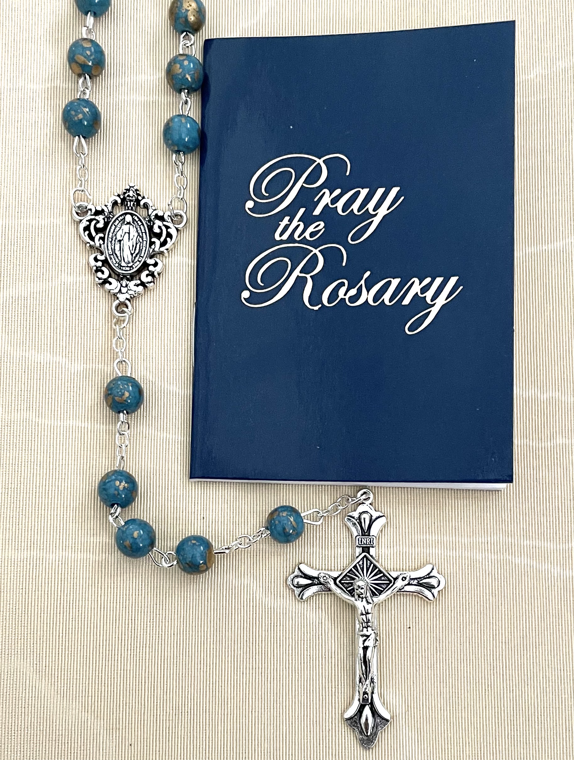 8MM SAPPHIRE GOLD SPECKLED ROSARY WITH HOW TO SAY THE ROSARY BOOKLET. PACKAGED IN HANGING BAG FOR DISPLAY PURPOSES