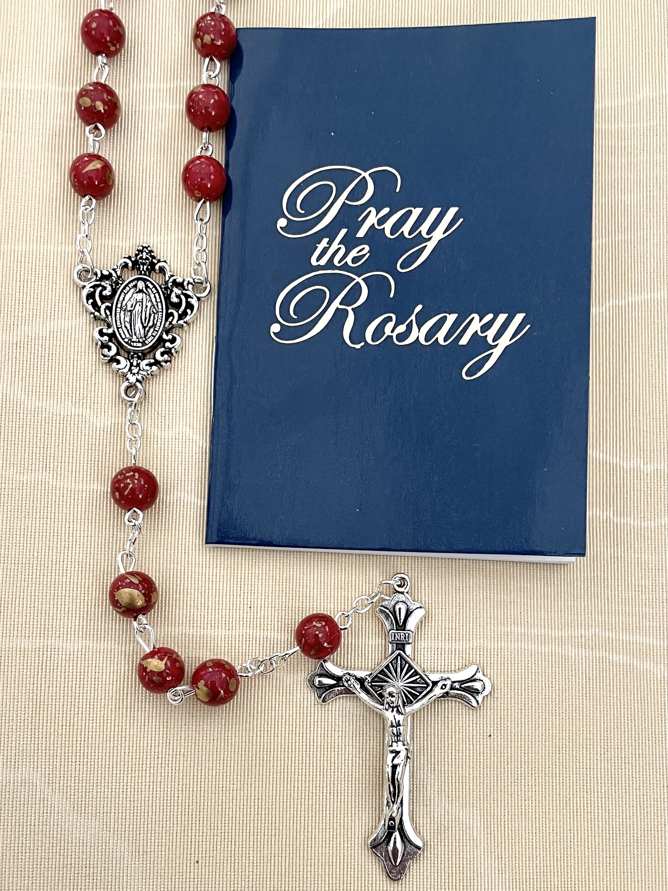 8MM RUBY GOLD SPECKLED ROSARY WITH HOW TO SAY THE ROSARY BOOKLET. PACKAGED IN HANGING BAG FOR DISPLAY PURPOSES