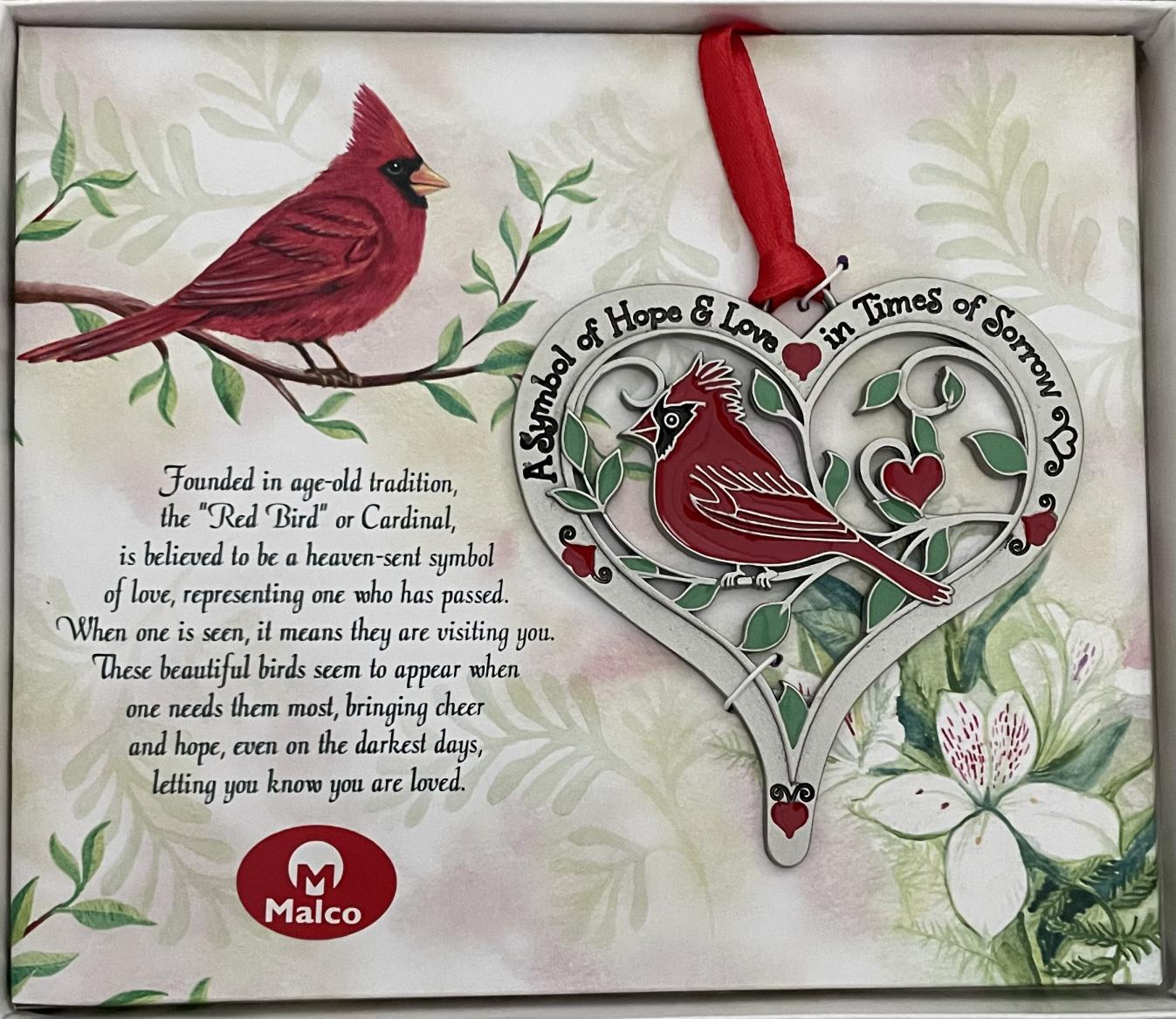 CARDINAL HEART ORNAMENT. A SYMBOL OF HOPE AND LOVE. SILVER ENAMEL FINISH METAL ACCENTED WITH RED AND GREEN EPOXY. HANGS ON RED RIBBON. 3.25 IN X 3.5 IN. WINDOW BOXED WITH STORY OF THE CARDINAL