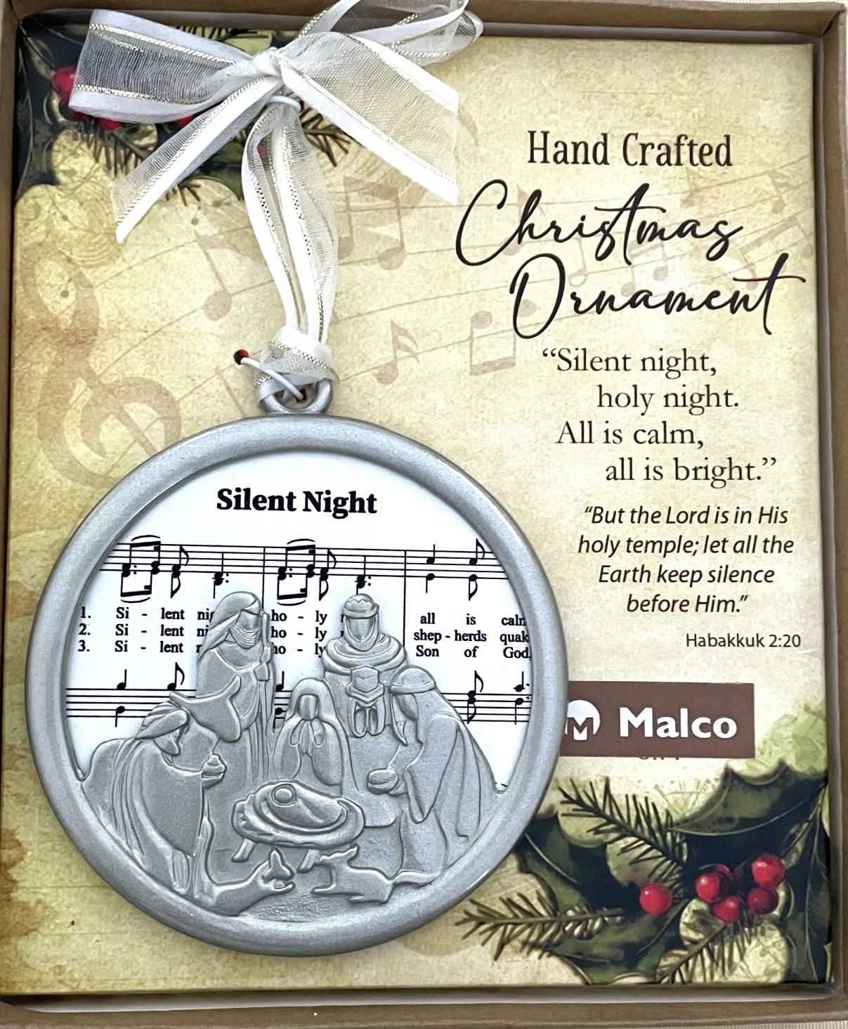 SILENT NIGHT CHRISTMAS CAROL ORNAMENT. CAST METAL, FINISHED IN SILVER ENAMEL, FRAME SUBLIMATED WOOD WHICH FEATURES SHEET MUSIC. HANGS FROM WHITE ORGANZA RIBBON. ORNAMENT SITS ON A DECORATIVE PAD, HIGHLIGHTING A SEFMENT OF THE CAROL WITH CORRESPONDING SCRIPTURE. 3.5 IN DIAMETER. WINDOW BOXED