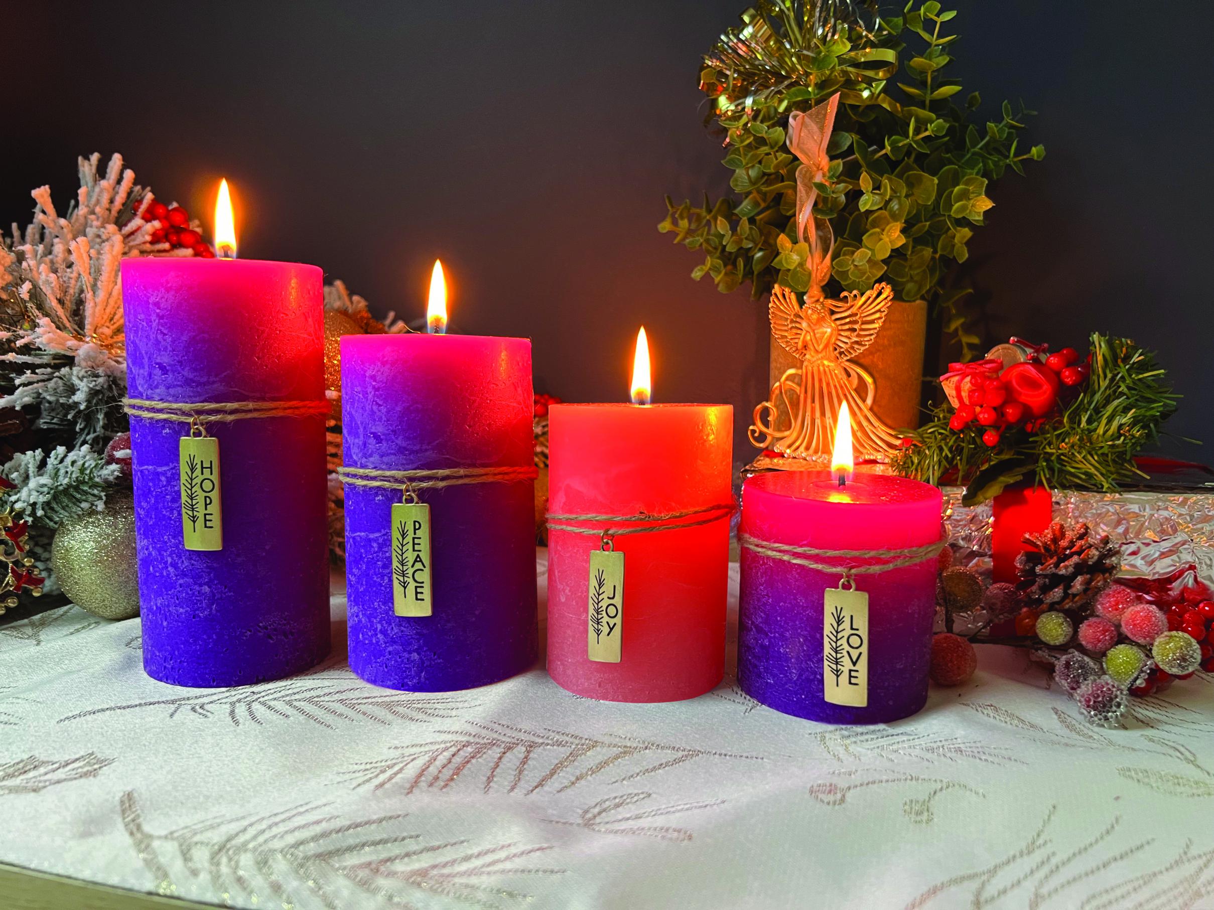 ADVENT PILLAR CANDLES FEATURING A TWINE WRAP AND CAST METAL CHARMS. THE SET INCLUDES THREE PURPLE PILLARS 6IN, 5IN AND 3IN AND ONE PINK THAT IS 4IN HIGH. ADVENT BROCHERE INCLUDED