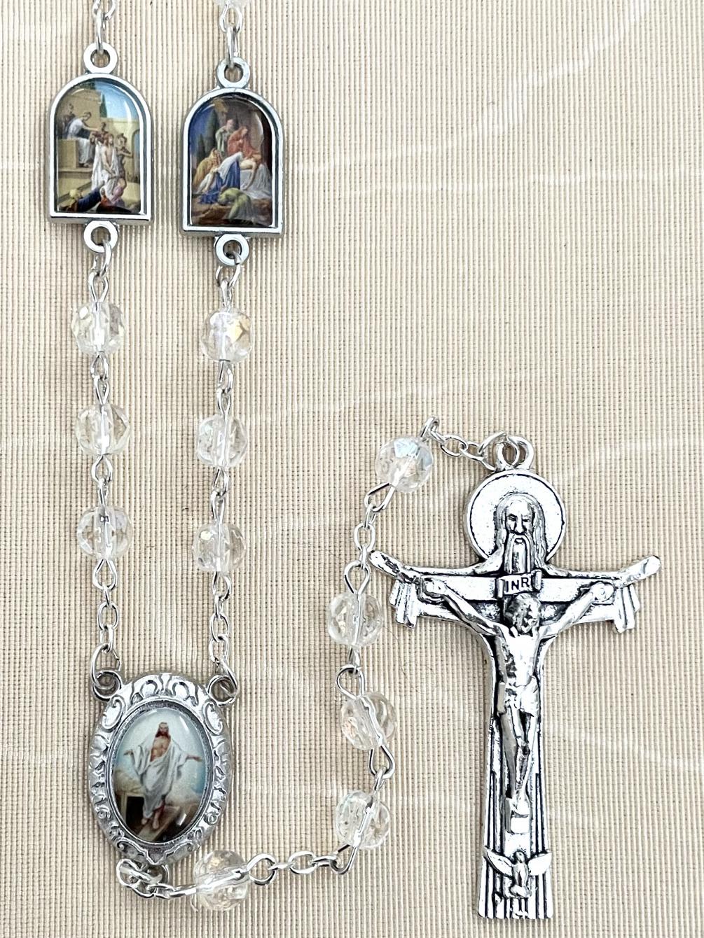 6MM CRYSTAL AB STATIONS OF THE CROSS ROSARY FEATURING ENAMEL METAL MEDALS DEPICTING THE STATIONS AS THE OUR FATHER BEADS. GIFT BOXED WITH PRAYER CARD.