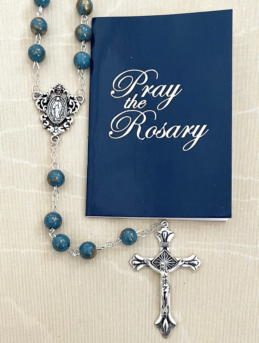 8MM SAPPHIRE GOLD SPECKLED ROSARY WITH HOW TO SAY THE ROSARY BOOKLET. PACKAGED IN HANGING BAG FOR DISPLAY PURPOSES